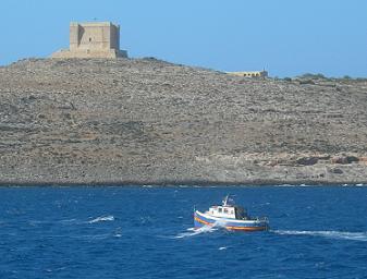 Un bateau traditionnel maltais devant le fort de Comino